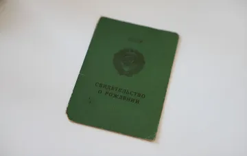 Зеленое советское свидетельство о рождении СССР с гербом, лежащее на белом фоне — актуально для статьи о замене документов в 2026 году