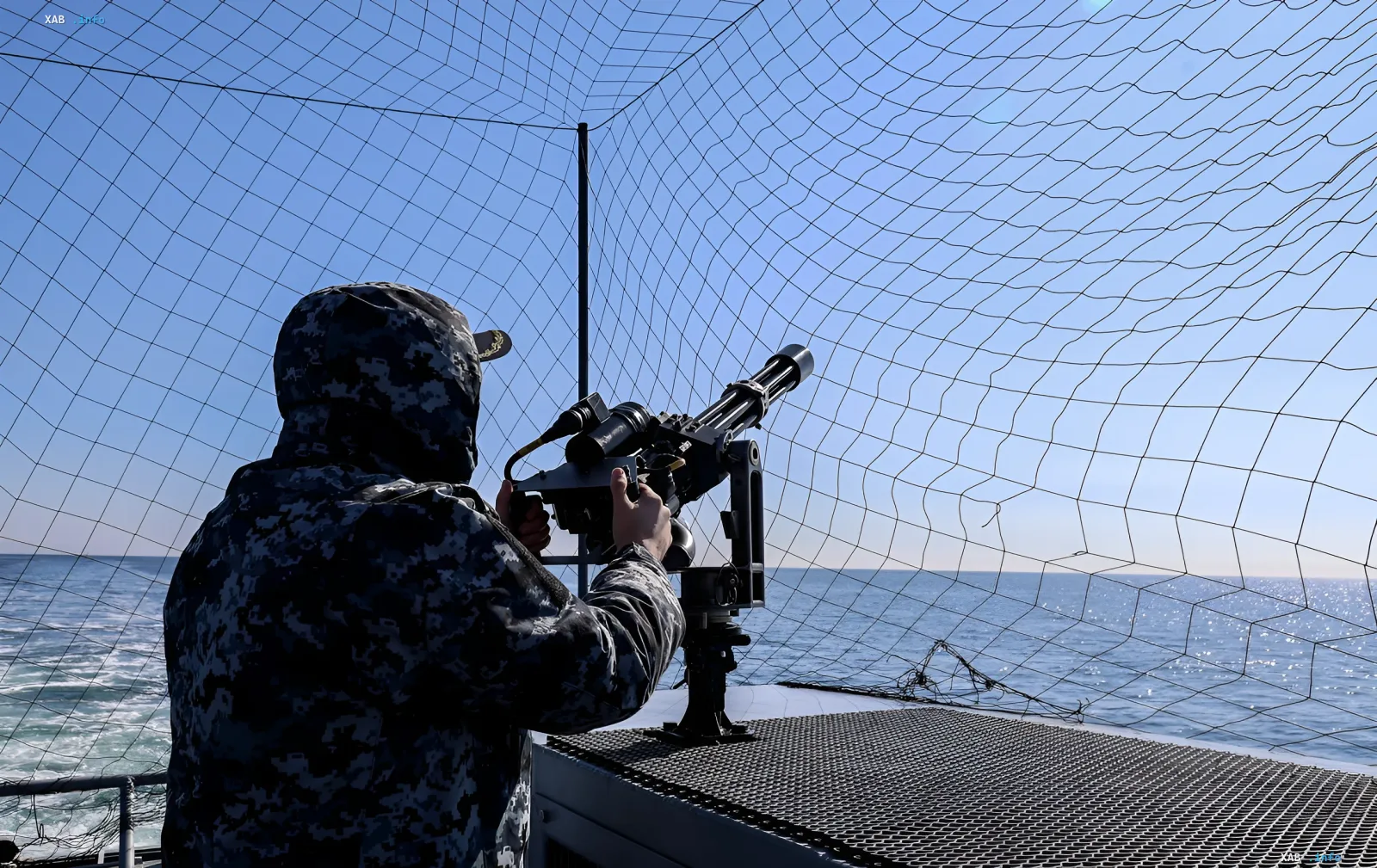 Ukrainian Navy sailor in camouflage operates an anti-aircraft machine gun on a ship deck in the Black Sea — symbol of defense against Russian drones after strike on 'Sivash'