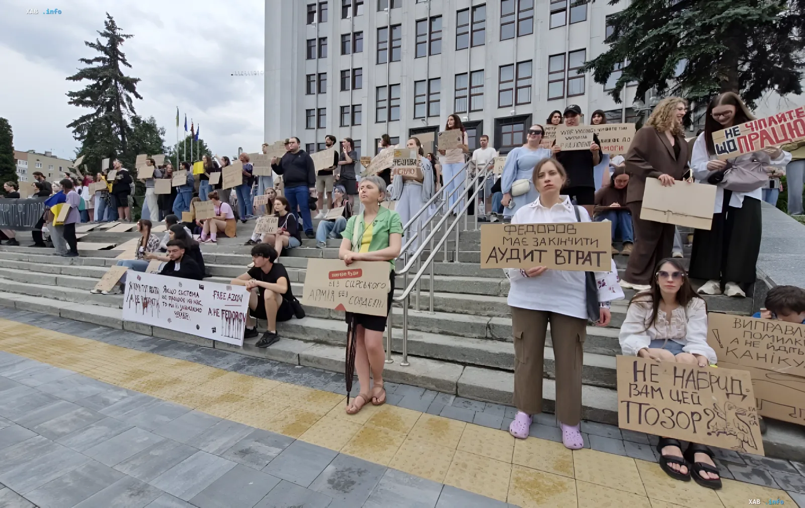 Митингующие с плакатами на ступенях здания в Киеве: визуальный контекст к новости о задержании и разоблачении фейков