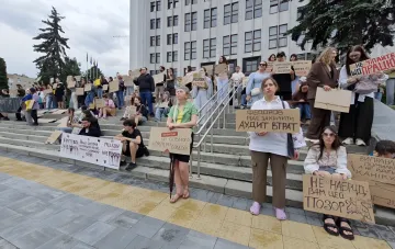 Митингующие с плакатами на ступенях здания в Киеве: визуальный контекст к новости о задержании и разоблачении фейков
