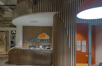 Логотип Cloudflare на стене офиса: символ инноваций, стоящих за запуском Kitesurf — первого облачного браузера для ИИ-агентов
