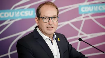 Deutscher Verkehrsminister Andreas Dobrindt spricht über hybride Kriegsführung und Sabotage in Leipzig vor dem Hintergrund des CDU/CSU-Logos