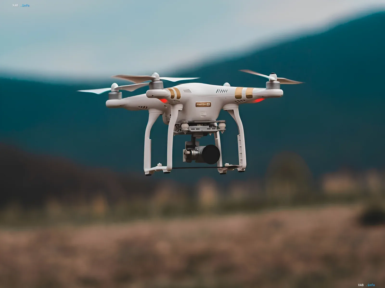 Білий дрон DJI в польоті на фоні гір — ілюстрація до новини про ретроактивне скасування FCC дозволів на дрони «військового класу», що торкнулося DJI та інші бренди