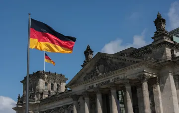 Die deutsche Flagge weht über dem Reichstagsgebäude in Berlin, was die politische Entscheidung zur Reduzierung des russischen Botschaftspersonals symbolisiert.