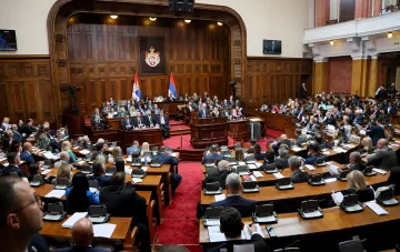 Заседание парламента Сербии: депутаты на учредительной сессии в зале с гербом и флагами
