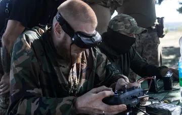 Украинский оператор дрона в камуфляже управляет БПЛА, готовясь к удару по российским военным объектам, включая С-400 в Геленджике и корабли Черноморского флота