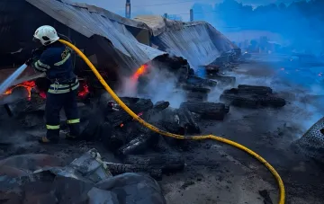 Firefighter extinguishing fire in the burned kennel of the 'Sirius' shelter near Kyiv, where 8 dogs perished