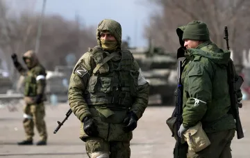 Russische Soldaten mit Erkennungszeichen 'Z' vor dem Hintergrund militärischer Ausrüstung auf dem Süd-Slobodschen Sektor