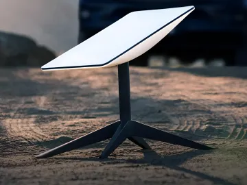 Portable Starlink Mini antenna set up on sand, showcasing the device's mobility and ease of use in field conditions.
