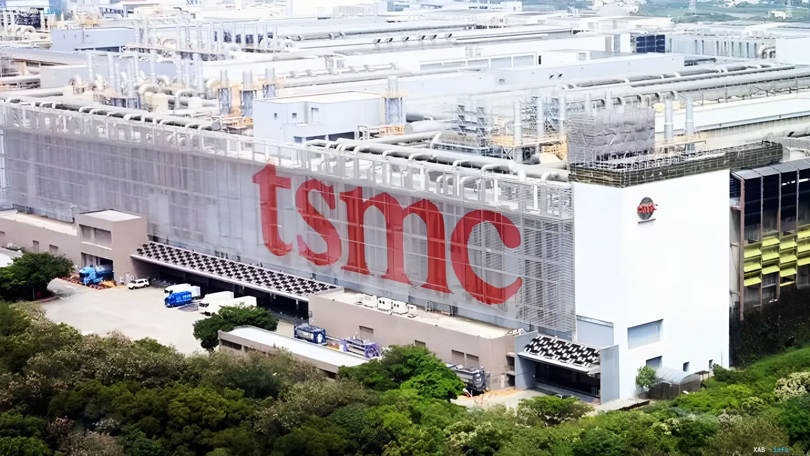 Завод TSMC с красным логотипом на фасаде, где разрабатываются передовые 2D-транзисторы на основе MoS₂ в сотрудничестве с NYCU