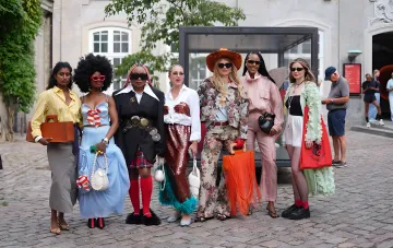 Группа модниц на Copenhagen Fashion Week 2027 демонстрирует яркий эклектичный стиль, контрастирующий со скандинавским минимализмом