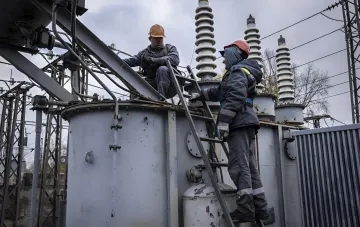 DTEK energy workers restoring a damaged transformer at a substation after shelling