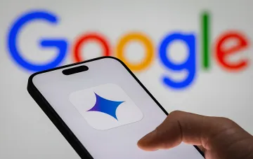 Смартфон с логотипом Gemini на экране перед размытым логотипом Google, иллюстрирующий утечку данных из Google Docs