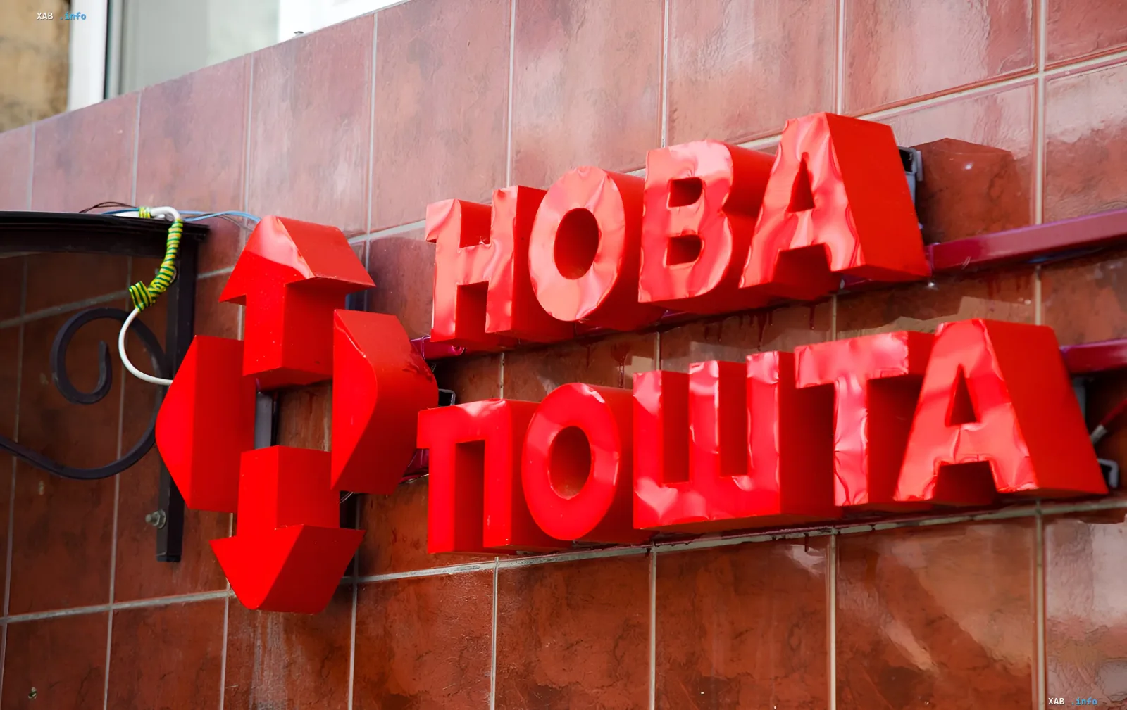 Яркий красный вывеска «НОВА ПОШТА» на фасаде здания — символ компании, отменившей увольнения сотрудников после инцидента с собакой в жару