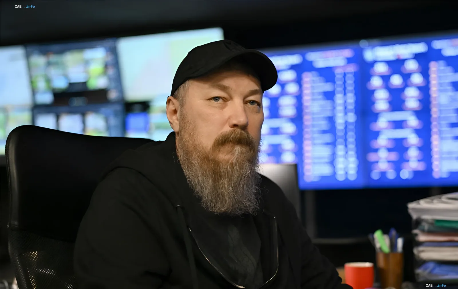 Андрей Мадяр в рабочем кабинете с мониторами на фоне, комментируя наращивание ракетных залпов Россией