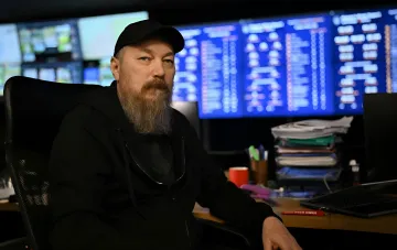 Оператор в центре управления мониторингом ракетных угроз, анализирующий данные на экранах перед эскалацией массированных ударов