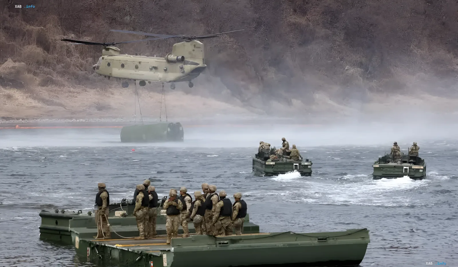 US- und südkoreanische Soldaten auf schwimmenden Plattformen während der Übungen Freedom Shield Ulchi 2026, Hubschrauber hebt Ausrüstung über Fluss