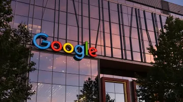 Логотип Google на фасаде современного здания Alphabet в сумерках, символизирующий масштабные инвестиции компании в развитие искусственного интеллекта