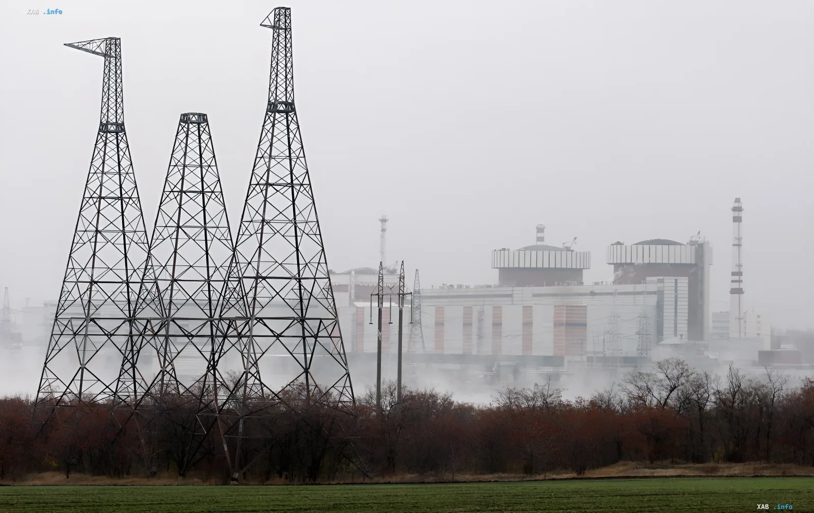 Nuclear power plant shrouded in fog with tall metal transmission towers in the foreground, symbolizing the dominance of nuclear energy in Ukraine’s electricity market structure in 2025