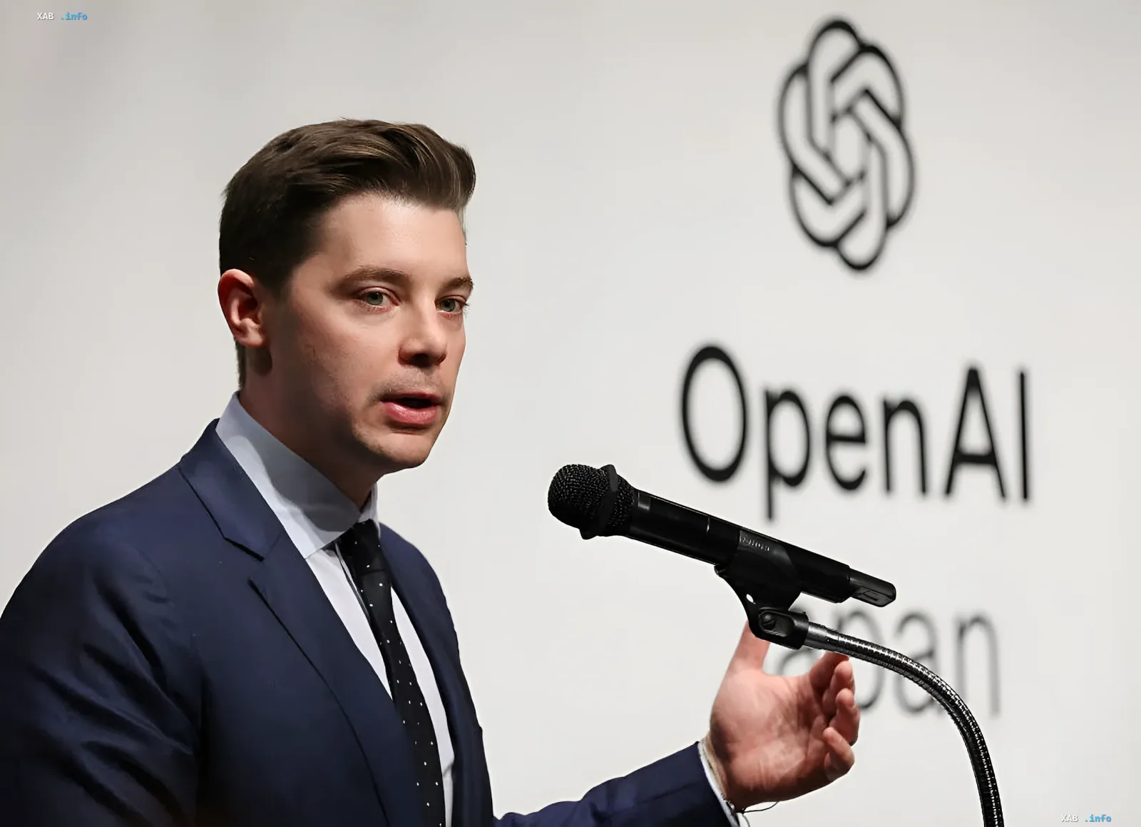 Brad Lightcap spricht vor dem OpenAI-Logo vor seinem Ausscheiden aus dem Unternehmen
