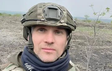 Юрій Бутусов у військовому одязі на фоні місцевості, обговорюючи поточні темпи наступу російських військ без нової мобілізації