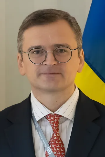 Український політик у окулярах та діловому костюмі на тлі українського прапора, що обговорює дефіцит систем ППО та перспективи захисту від балістичних загроз у 2026 році