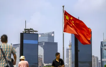 Chinesische Flagge weht vor einem modernen Stadtbild, symbolisiert Pekings Warnung an die USA über die Folgen neuer Sanktionen gegen Russland