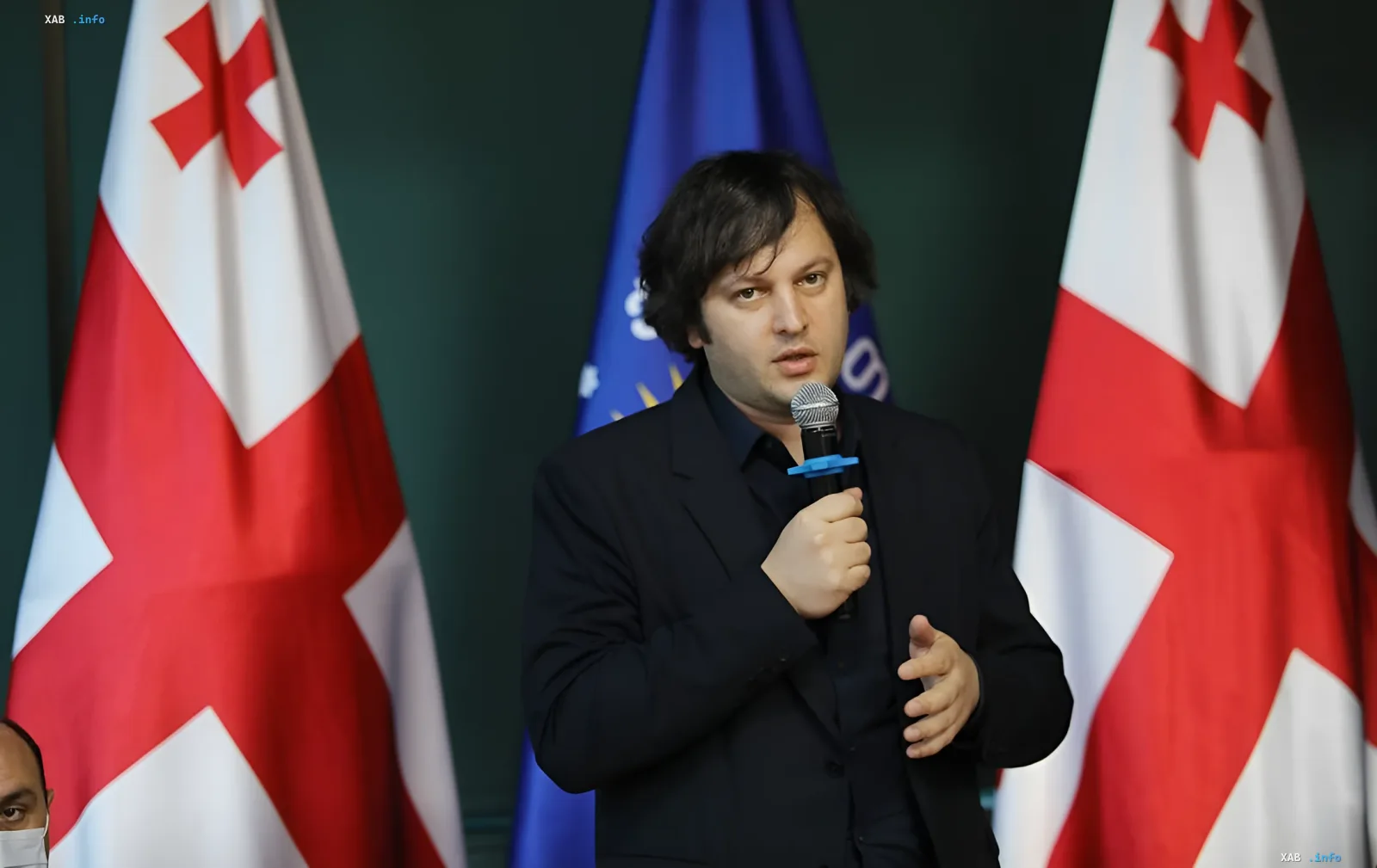Georgian Prime Minister Irakli Kobakhidze speaks at a press event with Georgian and EU flags behind him, stating a hard condition for restoring diplomatic ties with Russia