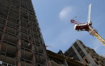 Abgebrochener Bau eines Wohnkomplexes der Business-Klasse: unfertige Gebäude und Kräne vor dem Himmel