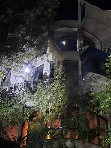Damaged five-story building in Odesa after drone strike: night view of facade destruction