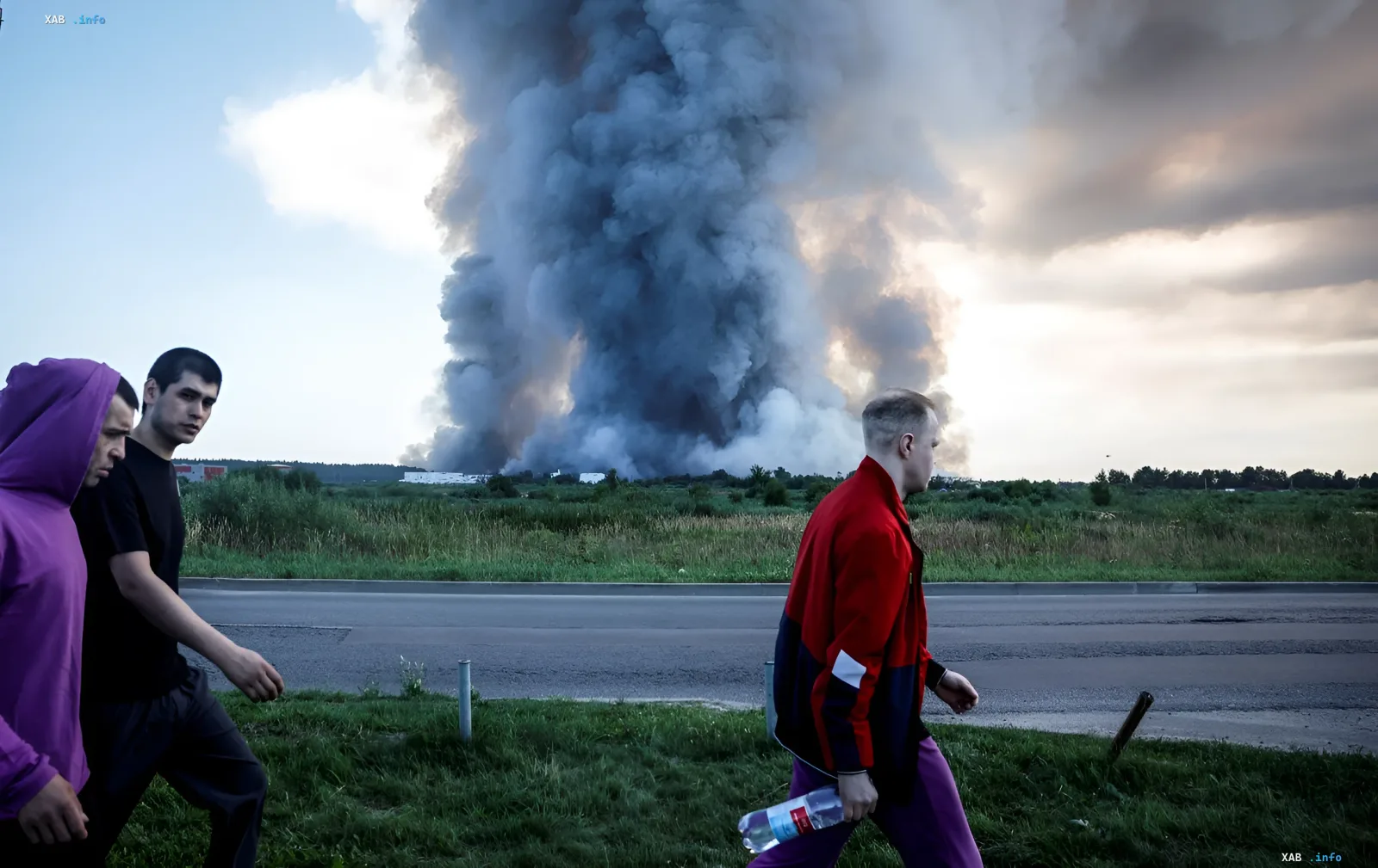 Huge column of black smoke over Wildberries warehouse near Voronezh, people walk past the road against the backdrop of the fire