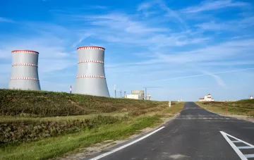 Massive cooling towers of a nuclear power plant in Romania against a clear sky, symbolizing the struggle for energy stability