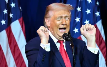 Дональд Трамп на фоне американских флагов, эмоционально выступает с речью, что контрастирует с его тайным побегом из саммита НАТО в Турции через фургон с едой из-за угрозы Ирана.