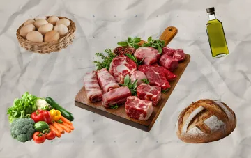 Корзина яиц, свежее мясо, овощи, оливковое масло и хлеб на белом фоне — иллюстрация к новости о ценах на продукты в Украине 11 августа