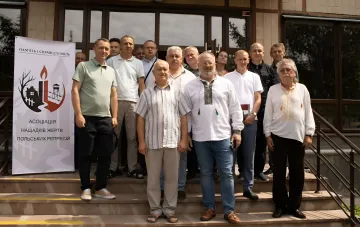 Група учасників першої всеукраїнської асоціації нащадків жертв польських репресій на сходах будівлі в Тернополі з банером «Пам'ять і справедливість»
