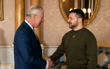 Король Чарльз III и президент Украины Владимир Зеленский пожимают руки во время встречи в роскошном зале, обсуждая планы британской делегации в августе 2026 года.