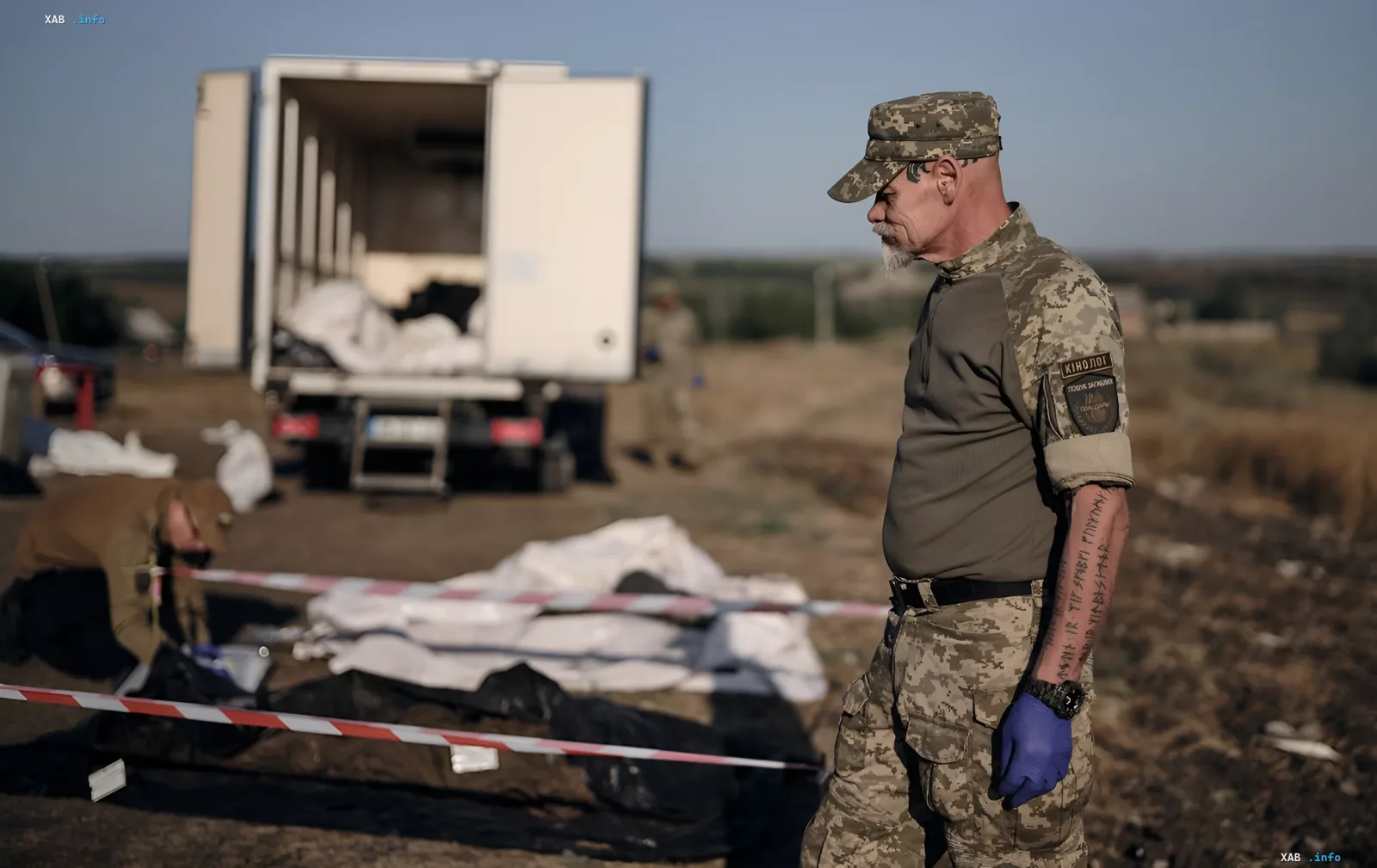Сотрудник криминальной полиции Украины осматривает место эксгумации тел погибших в плену, подтверждая данные о 375 жертвах