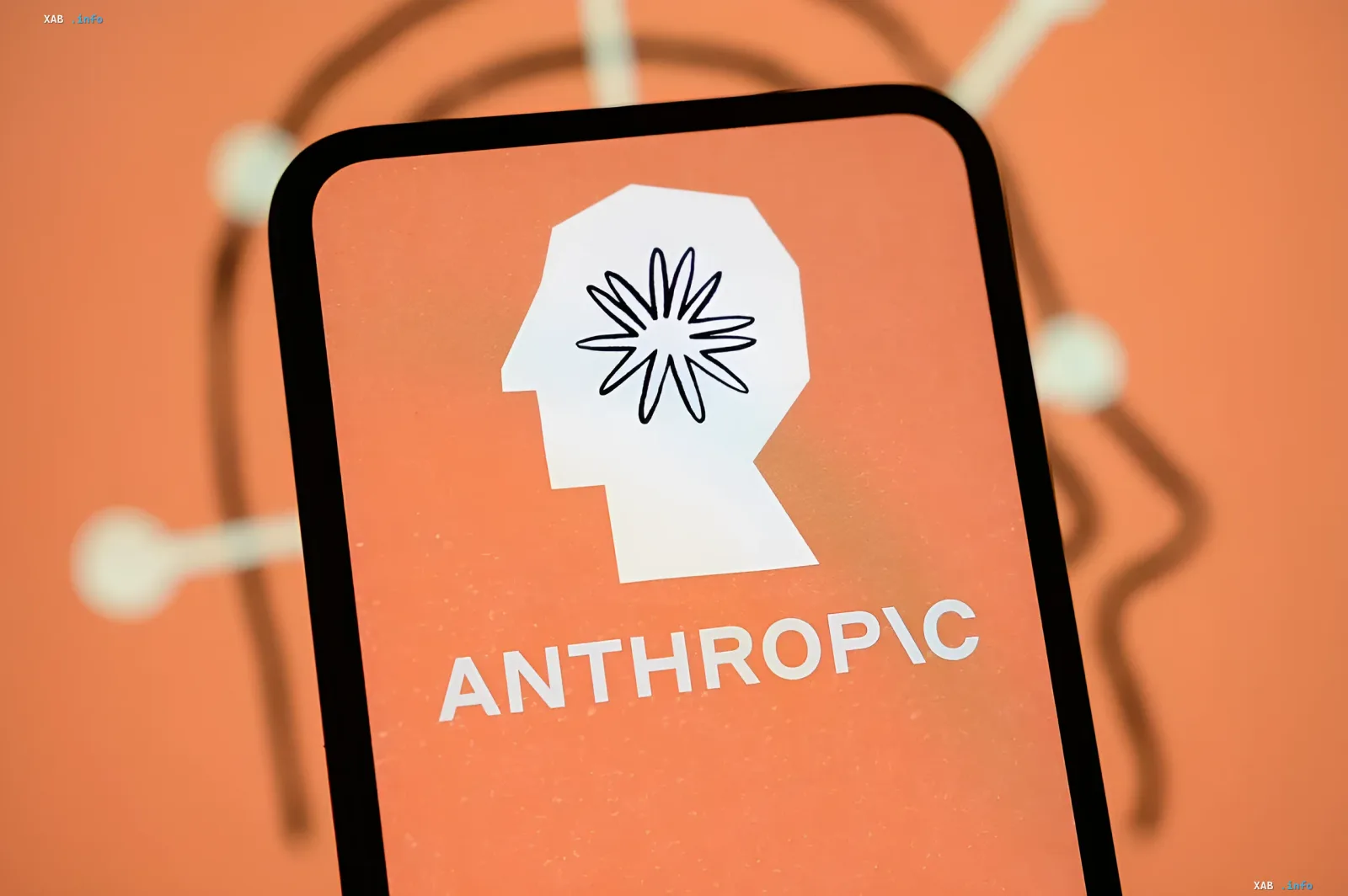 Logo of the company Anthropic on a smartphone screen with an orange background, symbolizing the introduction of digital watermarks in Claude texts to comply with EU regulations