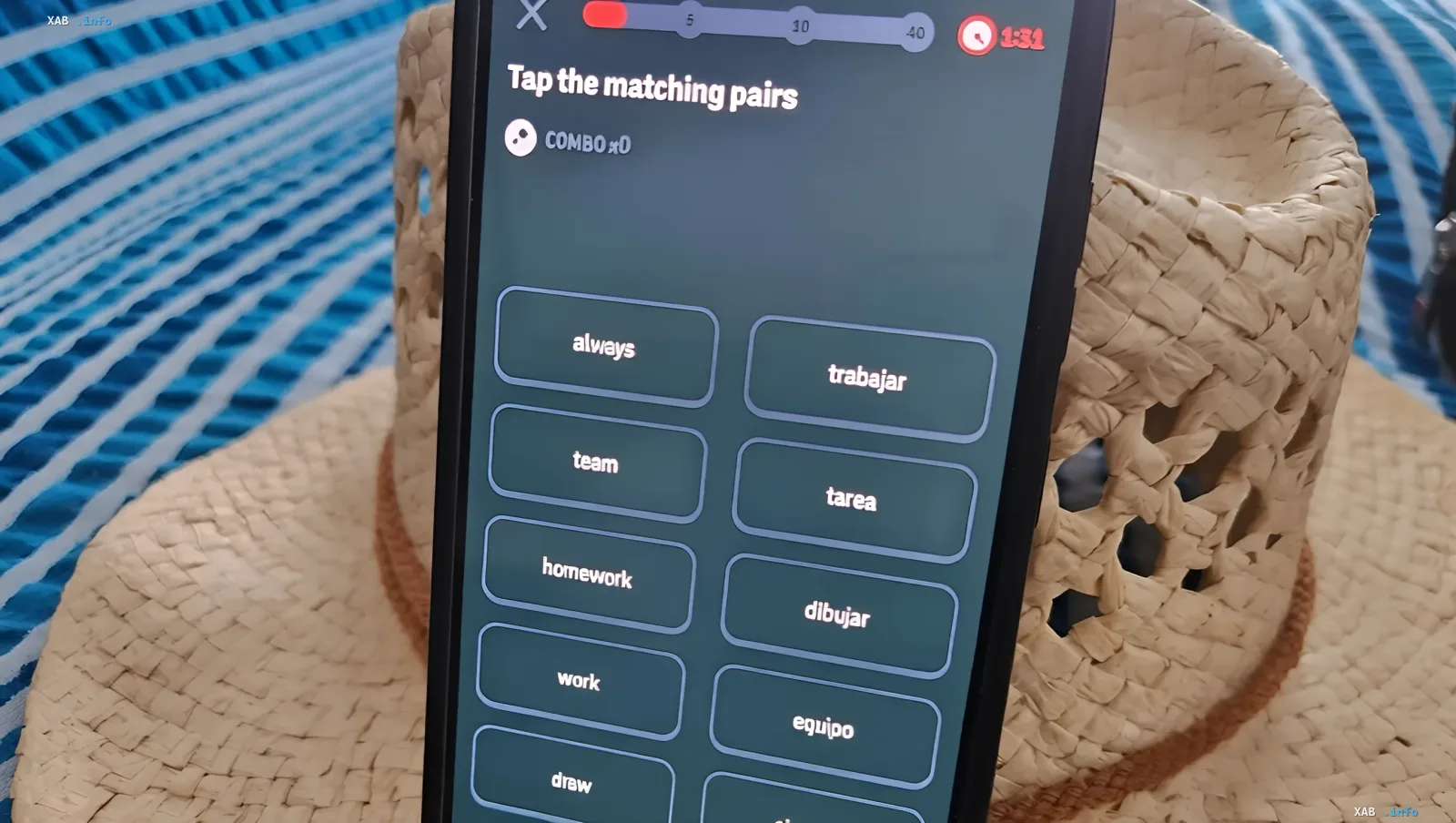 Smartphone-Bildschirm mit Duolingo-Spielmodus 'Tap the matching pairs' vor einem geflochtenen Korb – Illustration zur Meldung über das Testen der Undo-Taste