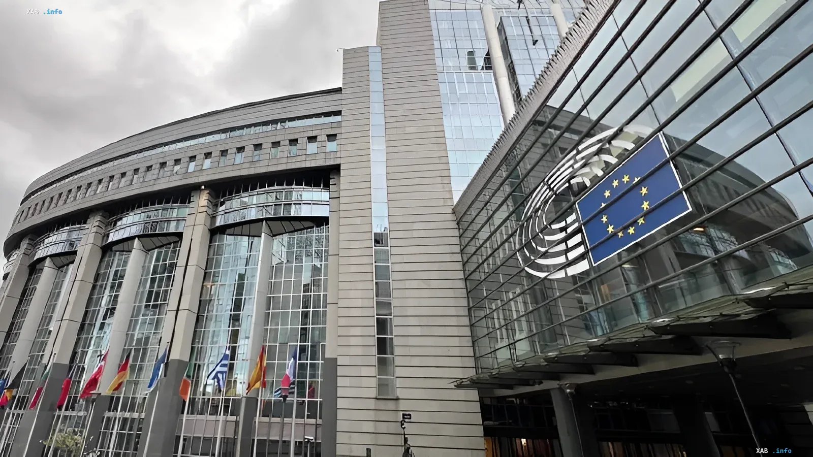European Commission building in Brussels with EU member flags and EU emblem — site of expansion decisions slowed by France and Germany in 2026
