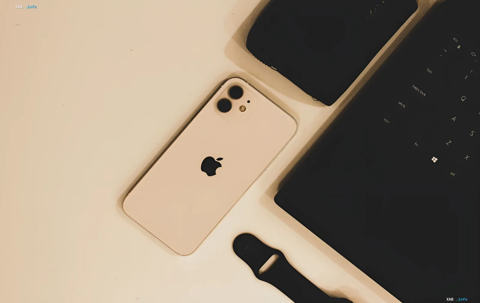 Золотой iPhone с двумя камерами на белом столе рядом с клавиатурой — намёк на будущие модели iPhone Ultra и Air в iOS 27