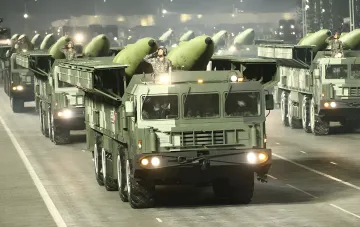 Парад северокорейских ракетных комплексов: военнослужащие салютуют на фоне баллистических ракет, демонстрируя военную мощь КНДР в ответ на учения США и Южной Кореи