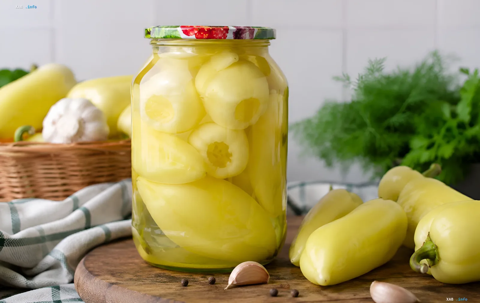 Стеклянная банка с маринованными желтыми перцами, сохраненными на зиму, рядом с свежими овощами и специями