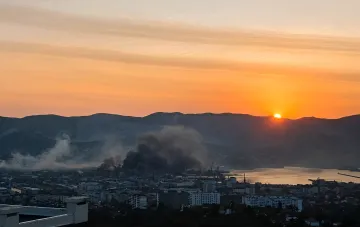 Noworossijsk in Flammen: dicker schwarzer Rauch steigt über die Stadt bei Sonnenuntergang nach einem nächtlichen Angriff der ukrainischen Streitkräfte