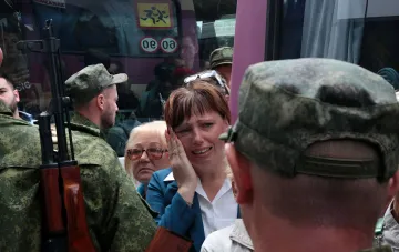 Плачущая женщина в окружении военных с автоматами во время уличного рейда по мобилизации в Омске