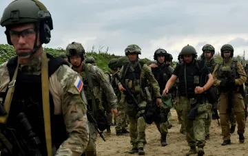 Российские военные в камуфляже с флагом РФ на рукавах маршируют по пустынной местности, иллюстрируя пропагандистские фейки о захвате несуществующих сел в 2026 году