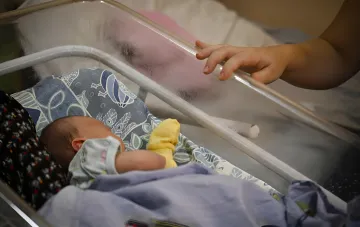 Newborn baby in a hospital crib, illustrating the issue of birth tourism in the USA