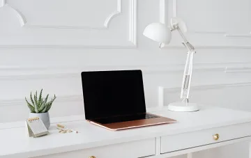 MacBook на рабочем столе с выключенным экраном — идеальная иллюстрация для статьи о скрытых возможностях скриншотов в macOS