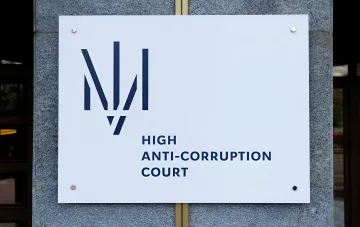 Schild des Obersten Antikorruptionsgerichts (HACC) an der Gebäudefassade, das den Prozess im Fall 'Rotterdam+' und die Kritik an seiner Unparteilichkeit symbolisiert
