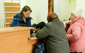 Пенсионеры получают социальные выплаты в отделении банка перед переходом на Укрпочту